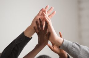 A group of hands high-five each other